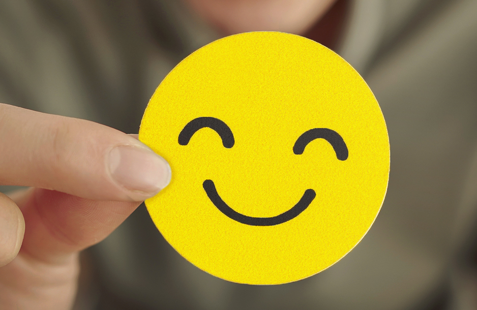 fingers holding smiley face